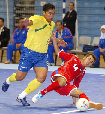 Thai player Narongsak Khongaews trying to stop the brazilian pivot Indio (Photo courtesy: Leadtek Sports)