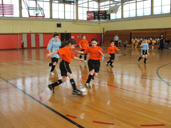 St. Michael*s Team players scramble for a loose ball while playing in Catholic Youth Futsal League game at Bishop Connolly High School (Courtesy: New England Futsal)